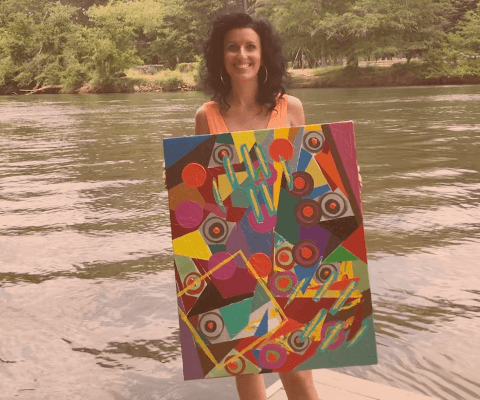 Anna Szabo at The Lodge of The Chattachoochee holding her original acrylic abstract painting called FEELINGS from Paintings with Tales collection