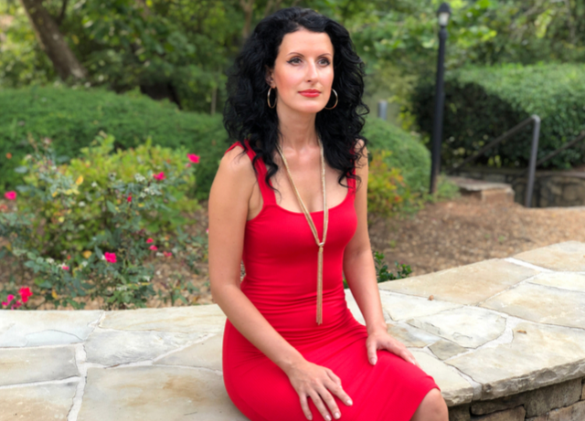 Anna Szabo of Online Discipleship for Women is sitting near the river in a red dress thinking about "My suicide story"